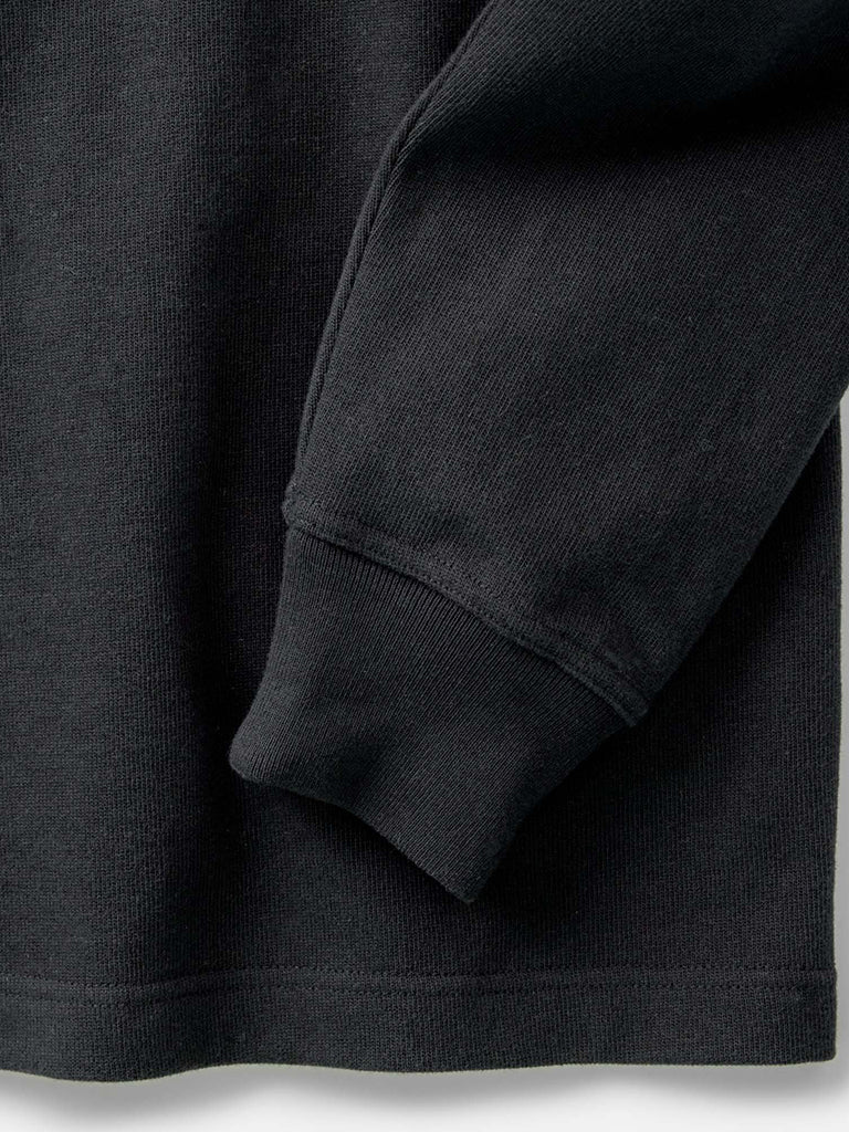Close-up of a black garment, showing the texture and cuff detail.