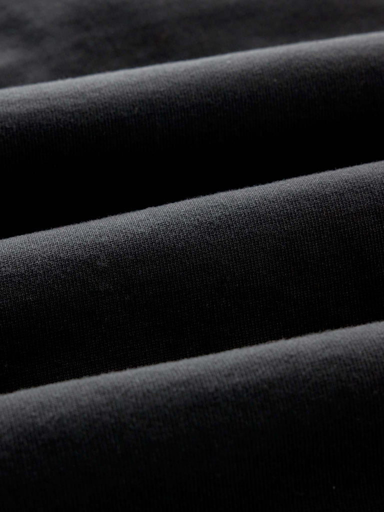 A close-up of draped black fabric showing its soft texture and folds.