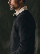 profile of a man wearing a black polo