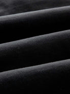 A close-up of draped black fabric showing its soft texture and folds.