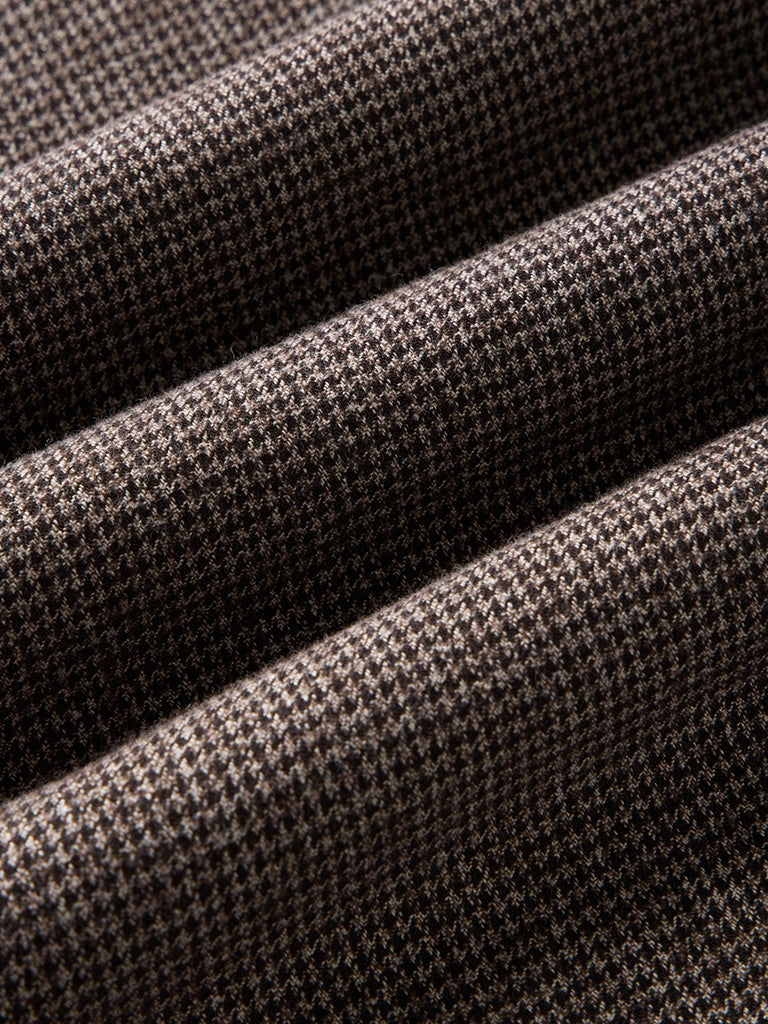 A close-up of fabric with a houndstooth pattern in brown and black.