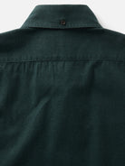 Close-up of the back collar of a green textured button-down shirt