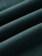 A close-up of green knit fabric with houndstooth details